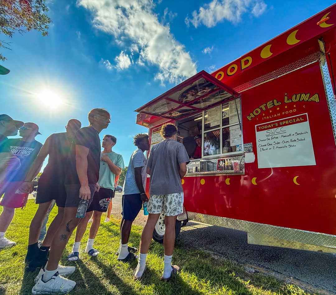 Students waiting in line at a food truck on campus during move-in weekend
