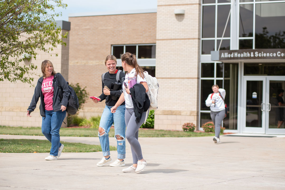 Students walking on campus in front of the Allied Health & Science Center