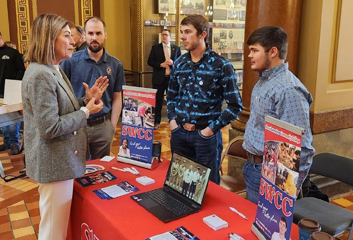 Welding students speaking with Gov. Kim Reynolds