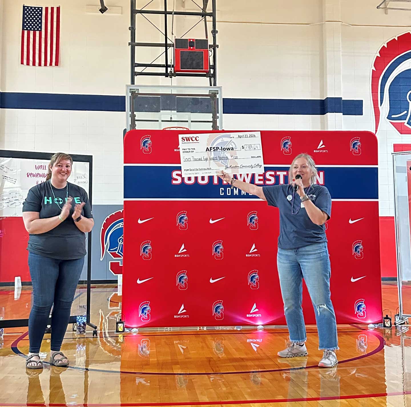 Amara Huffline, AFSP Iowa Chapter, and Terri Higgins, SWCC marketing director, with a check at the 2026 event