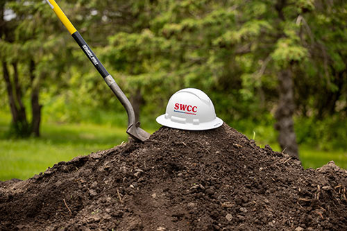 SWCC hard hat and shovel on mound of dirt