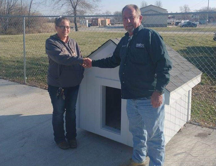 Sarah Farlow (at left) accepts three SWCC doghouses on behalf of the Clarke County Animal Shelter. Also pictured is Ron Utley, SWCC carpentry and building trades instructor.