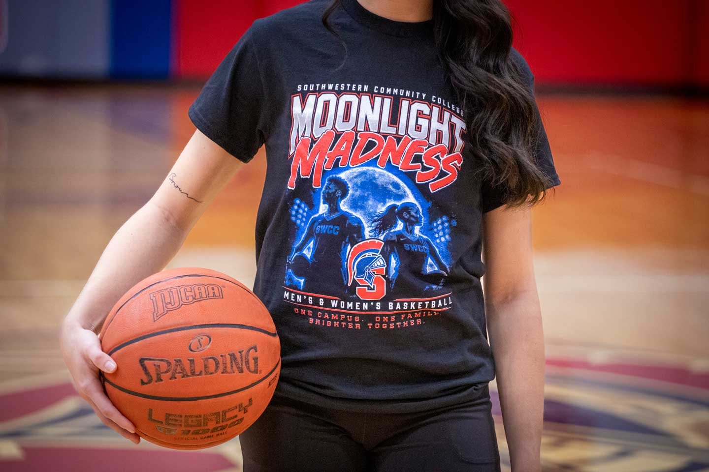 Female student modeling Moonlit Madness black T-shirt with basketball silhouettes