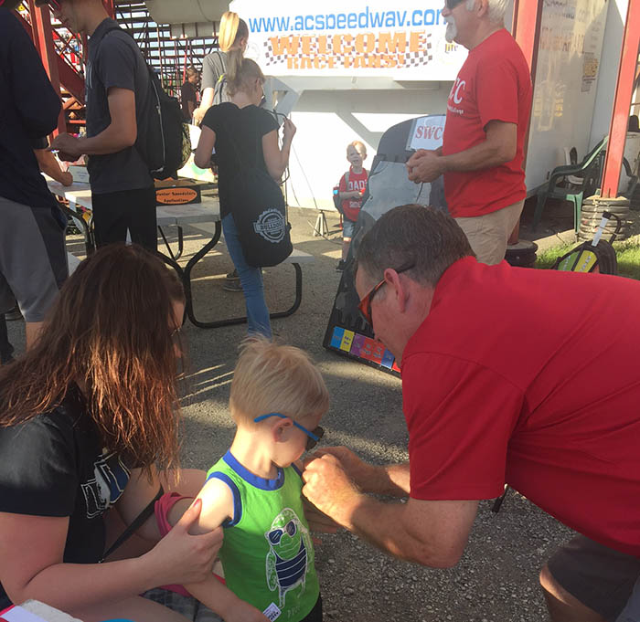 SWCC volunteer applying temporary tattoo on child
