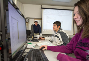 Girl at computer with instructor in background