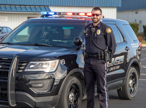 Police officer in front of patrol vehicle