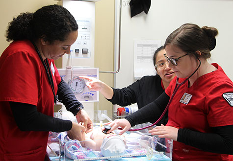 Nursing students with instructor working in the simulation lab
