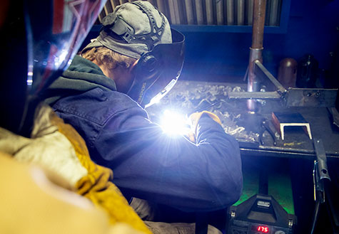 Student welding on a large project