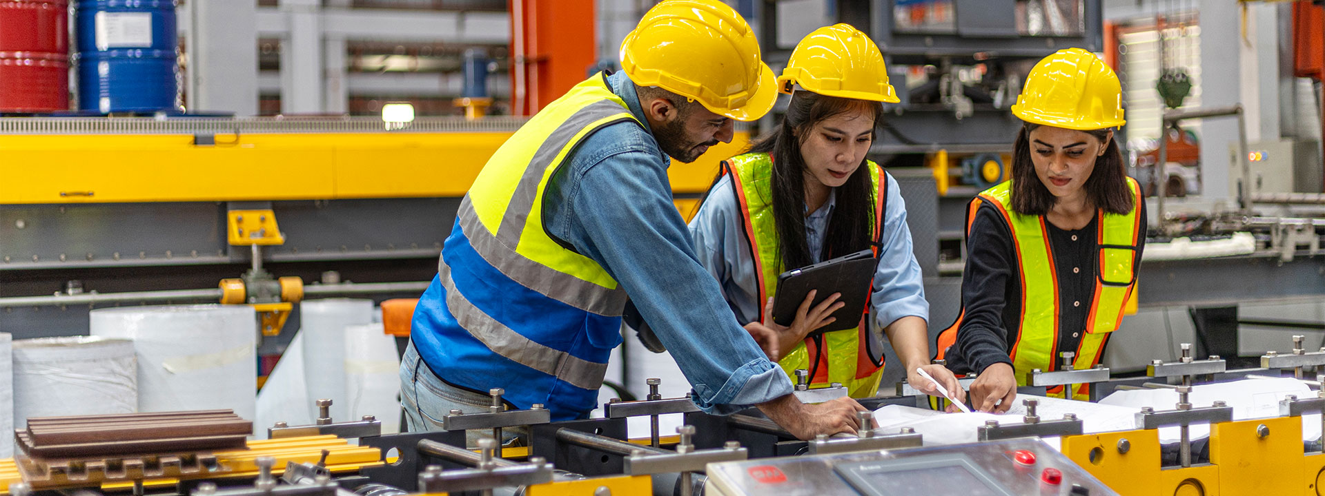 Group of people looking at blueprints in a factory environment