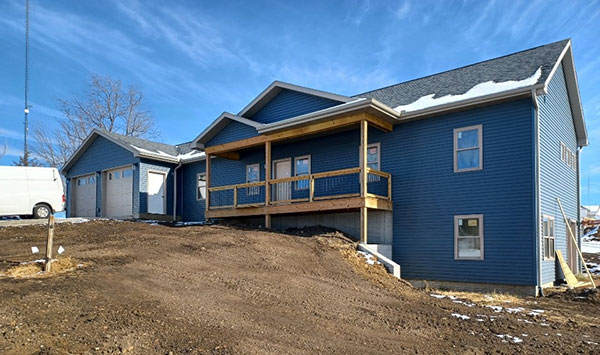 Student carpentry house in Diagonal with blue siding and a deck