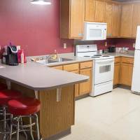 kitchen area with seating, sink, oven, microwave, refrigerator, and plenty of cupboard space.