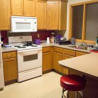 kitchen area with seating, sink, oven, microwave, refrigerator, and plenty of cupboard space.