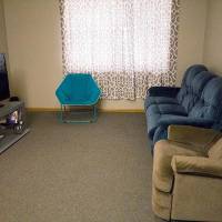 shared living room with chairs, a couch, and a TV.