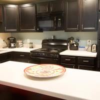 view of the kitchen area with refrigerator, oven, microwave, and cupboards