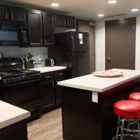 View of the kitchen with stool seating, Refrigerator, stove, microwave, and cupboards