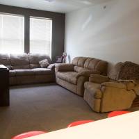 Living room area with couch chairs, and TV.