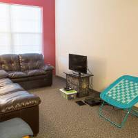 Living room couch, chairs, and TV.