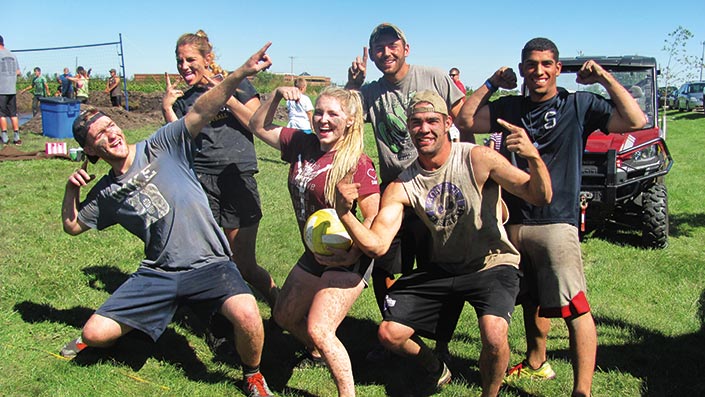 mud volleyball team posing for the camera